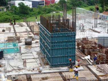 SELANGOR, MALAYSIA - 6 Temmuz 2021: İnşaat işçileri bir inşaat sahasında günlük rutin işleri ve temizlik işlerini yürütüyorlar. Bölgede güvenlik ekipmanı giymeleri gerekiyor..