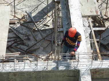 SELANGOR, MALAYSIA - 6 Temmuz 2021: İnşaat işçileri bir inşaat sahasında günlük rutin işleri ve temizlik işlerini yürütüyorlar. Bölgede güvenlik ekipmanı giymeleri gerekiyor..