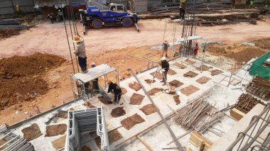 SELANGOR, MALAYSIA - 6 Temmuz 2021: İnşaat işçileri bir inşaat sahasında günlük rutin işleri ve temizlik işlerini yürütüyorlar. Bölgede güvenlik ekipmanı giymeleri gerekiyor..