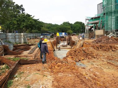 SELANGOR, MALAYSIA - 6 Temmuz 2021: İnşaat işçileri bir inşaat sahasında günlük rutin işleri ve temizlik işlerini yürütüyorlar. Bölgede güvenlik ekipmanı giymeleri gerekiyor..