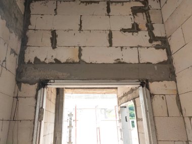 SELANGOR, MALAYSIA - 8 Mayıs 2021: Yukarıdaki tuğlaları desteklemek için kapı ve pencereler gibi duvar açıklarına beton kirişler monte edilir. Güçlendirilmiş betondan yapılmış..