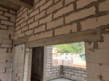 SELANGOR, MALAYSIA - 8 Mayıs 2021: Yukarıdaki tuğlaları desteklemek için kapı ve pencereler gibi duvar açıklarına beton kirişler monte edilir. Güçlendirilmiş betondan yapılmış..