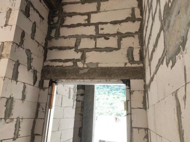 SELANGOR, MALAYSIA - 8 Mayıs 2021: Yukarıdaki tuğlaları desteklemek için kapı ve pencereler gibi duvar açıklarına beton kirişler monte edilir. Güçlendirilmiş betondan yapılmış..