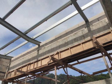 SELANGOR, MALAYSIA - 8 Mayıs 2021: Yukarıdaki tuğlaları desteklemek için kapı ve pencereler gibi duvar açıklarına beton kirişler monte edilir. Güçlendirilmiş betondan yapılmış..