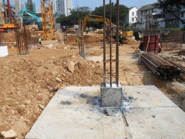 SELANGOR, MALAYSIA - 2 MAYIS 2022: İnşaat çalışması şantiyede yürütülüyor. Bina delik kazık ve kapak metodunu kullanıyor. İşçiler inşaat alanında meşguller..