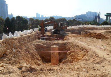 SELANGOR, MALAYSIA - 2 MAYIS 2022: İnşaat çalışması şantiyede yürütülüyor. Bina delik kazık ve kapak metodunu kullanıyor. İşçiler inşaat alanında meşguller..