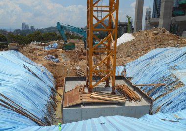 SELANGOR, MALAYSIA - 2 MAYIS 2022: İnşaat çalışması şantiyede yürütülüyor. Bina delik kazık ve kapak metodunu kullanıyor. İşçiler inşaat alanında meşguller..