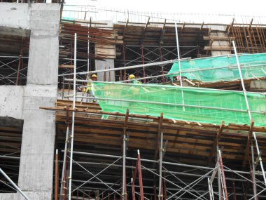 SELANGOR, MALAYSIA -JULY 16, 2018: Safety netting is installed at the high rise building exterior scaffolding during construction. Its avoid building object falling directly to the ground.