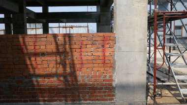 SELANGOR, MALAYSIA - 5 Mart 2022: tuğla tesisi şantiyelerde çalışır. Tuğlalar katmanlara yerleştiriliyor ve beton harçla birleştiriliyor.