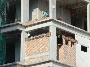 SELANGOR, MALAYSIA - 5 Mart 2022: tuğla tesisi şantiyelerde çalışır. Tuğlalar katmanlara yerleştiriliyor ve beton harçla birleştiriliyor.