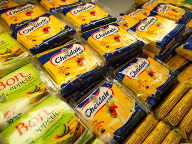 SELANGOR, MALAYSIA -12 APRIL 2022: Sliced cheese placed in commercial packs and displayed for sale. Each pack has several slices of cheese. Separated by brand, type and flavor.