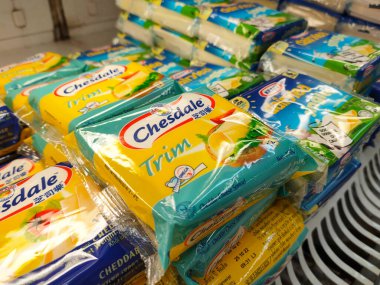 SELANGOR, MALAYSIA -12 APRIL 2022: Sliced cheese placed in commercial packs and displayed for sale. Each pack has several slices of cheese. Separated by brand, type and flavor.