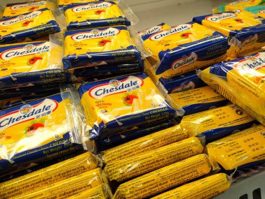 SELANGOR, MALAYSIA -12 APRIL 2022: Sliced cheese placed in commercial packs and displayed for sale. Each pack has several slices of cheese. Separated by brand, type and flavor.
