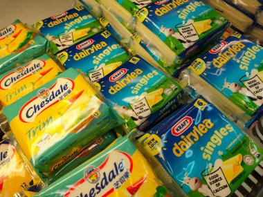 SELANGOR, MALAYSIA -12 APRIL 2022: Sliced cheese placed in commercial packs and displayed for sale. Each pack has several slices of cheese. Separated by brand, type and flavor.