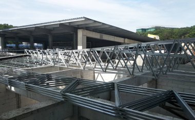 SELANGOR, MALAYSIA -16 Haziran 2021: İnşaat işçileri inşaat sahalarına kiriş ve çatı örtüleri kurar. Kullanılan hafif çatı kirişleri daha ekonomik, sağlam ve hızlıdır.