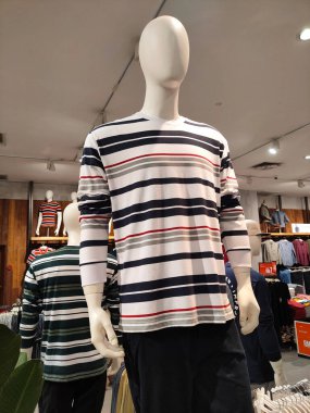 SELANGOR, MALAYSIA -4 NİSAN 2022: Mağazada çeşitli giyim türleri satılıyor. Asma ve katlama ile gösteriliyor. Alıcı incelemesi için fiyat etiketi var. Türüne ve markasına göre ayrılmış