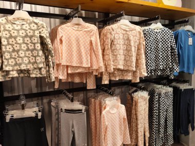 SELANGOR, MALAYSIA -APRIL 4, 2022: Various types of clothes are being sold in the store. Displayed by hanging and folding. Have a price tag for buyer review. Separated by type and brand