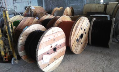 SELANGOR, MALAYSIA - JULY 7, 2022: PVC-coated electrical cables coiled in wooden drums. The use of a drum can help speed up the installation and ensure that the cable is not damaged.