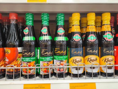 MELAKA, MALAYSIA - MARCH 4, 2022: Salty and sweet soy sauce bottled in glass bottles and displayed for sale. Labeled by brand and has a price tag. Separated by brand.