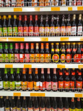 MELAKA, MALAYSIA - MARCH 4, 2022: Salty and sweet soy sauce bottled in glass bottles and displayed for sale. Labeled by brand and has a price tag. Separated by brand.