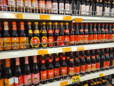 MELAKA, MALAYSIA - MARCH 4, 2022: Salty and sweet soy sauce bottled in glass bottles and displayed for sale. Labeled by brand and has a price tag. Separated by brand.