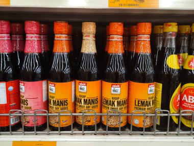 MELAKA, MALAYSIA - MARCH 4, 2022: Salty and sweet soy sauce bottled in glass bottles and displayed for sale. Labeled by brand and has a price tag. Separated by brand.
