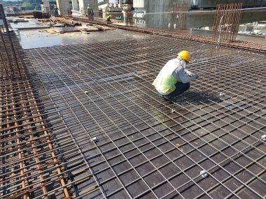 MELAKA, MALAYSIA -JULY 8, 2021: Floor slab reinforcement bar installed on timber plywood formwork. Services such as electrical conduits and water pipes are installed in it before being concreted.