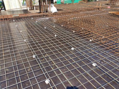 MELAKA, MALAYSIA -JULY 8, 2021: Floor slab reinforcement bar installed on timber plywood formwork. Services such as electrical conduits and water pipes are installed in it before being concreted.