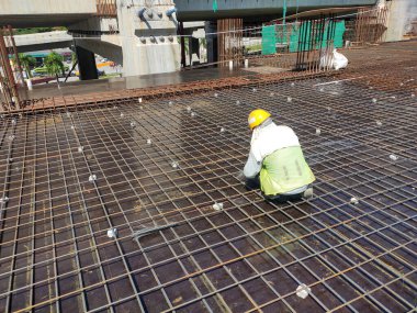 MELAKA, MALAYSIA -JULY 8, 2021: Floor slab reinforcement bar installed on timber plywood formwork. Services such as electrical conduits and water pipes are installed in it before being concreted.