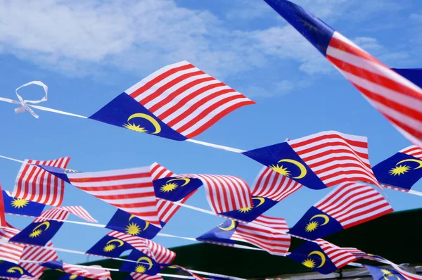 SELANGOR, MALAYSIA -AUGUST 31, 2021: Several small Malaysian flags are tied together and installed horizontally. These flags flutter when the wind blows.