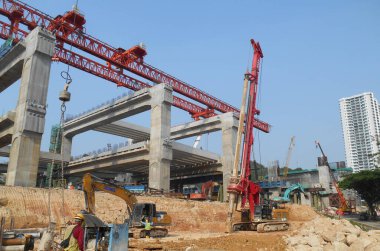 KUALA LUMPUR, MALAYSIA - 30 Mart 2022: İnşaat alanında kazık teçhizat makinesi. Bu makine vakıf inşaatı için hurda yığını sürüyordu. Yetenekli işçiler tarafından işletiliyor.. 