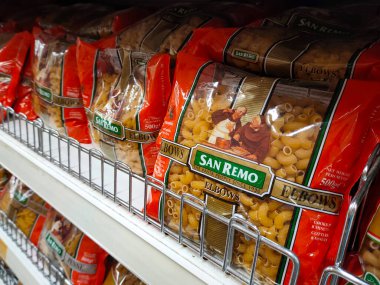 SELANGOR, MALAYSIA -AUGUST 5, 2022: Pasta and macaroni in commercial packs and displayed for sale on shelves. Separated by brand and type. Clearly labeled and has a price tag.