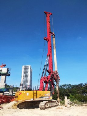 SELANGOR, MALAYSIA -JUNE 30, 2022: Bore pile rig machine at the construction site. The machine used to driven pile for building foundation work. Operated by skilled workers. Heavy machinery.