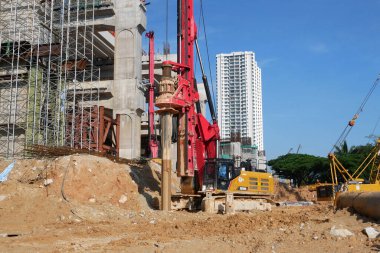 SELANGOR, MALAYSIA -JUNE 30, 2022: Bore pile rig machine at the construction site. The machine used to driven pile for building foundation work. Operated by skilled workers. Heavy machinery.