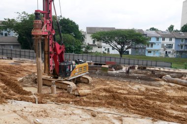 SELANGOR, MALAYSIA -JUNE 30, 2022: Bore pile rig machine at the construction site. The machine used to driven pile for building foundation work. Operated by skilled workers. Heavy machinery.