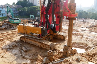 SELANGOR, MALAYSIA -JUNE 30, 2022: Bore pile rig machine at the construction site. The machine used to driven pile for building foundation work. Operated by skilled workers. Heavy machinery.