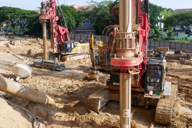 SELANGOR, MALAYSIA -JUNE 30, 2022: Bore pile rig machine at the construction site. The machine used to driven pile for building foundation work. Operated by skilled workers. Heavy machinery.