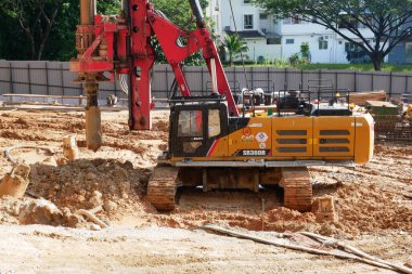 SELANGOR, MALAYSIA -JUNE 30, 2022: Bore pile rig machine at the construction site. The machine used to driven pile for building foundation work. Operated by skilled workers. Heavy machinery.