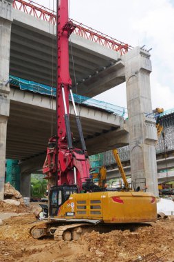 SELANGOR, MALAYSIA -JUNE 30, 2022: Bore pile rig machine at the construction site. The machine used to driven pile for building foundation work. Operated by skilled workers. Heavy machinery.