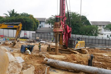 SELANGOR, MALAYSIA -JUNE 30, 2022: Bore pile rig machine at the construction site. The machine used to driven pile for building foundation work. Operated by skilled workers. Heavy machinery.