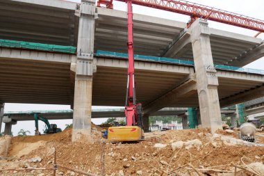 SELANGOR, MALAYSIA -JUNE 30, 2022: Bore pile rig machine at the construction site. The machine used to driven pile for building foundation work. Operated by skilled workers. Heavy machinery.