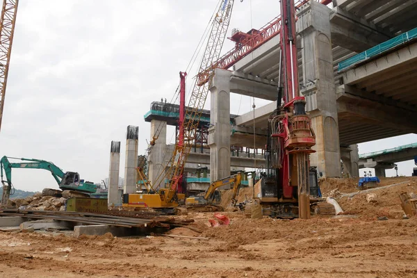 SELANGOR, MALAYSIA -JUNE 30, 2022: Bore pile rig machine at the construction site. The machine used to driven pile for building foundation work. Operated by skilled workers. Heavy machinery.