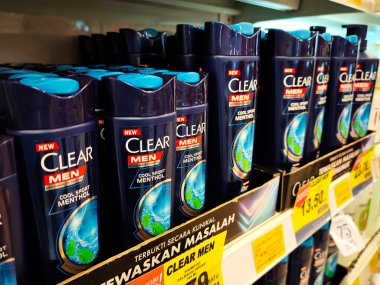 SELANGOR, MALAYSIA -JUNE 6, 2022: Selected focused on the hair shampoo in plastic bottle packaging, on display for sale on the shelves in the supermarket. Tagged with the price tag.