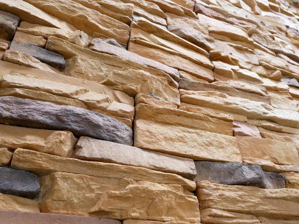 Artificial stone cladding. Designed to resemble real stone. Arranged vertically and attached to the wall with a special adhesive. Used as decoration on the walls of buildings.