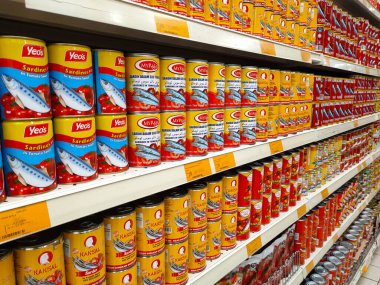SELANGOR, MALAYSIA -JULY 6, 2022: Selective focused on sardine fish can. The fish has been processed, cook and packed in the can. Displayed on the rack for sale and tag with the price tag