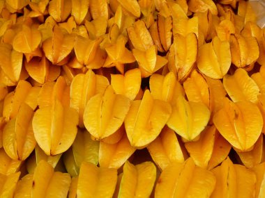 Ripe starfruit fruits have been harvested and displayed for sale. These fruits are arranged on top of each other and to look attractive.