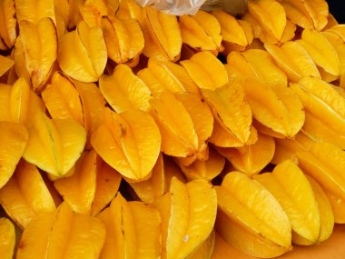 Ripe starfruit fruits have been harvested and displayed for sale. These fruits are arranged on top of each other and to look attractive.