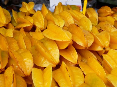 Ripe starfruit fruits have been harvested and displayed for sale. These fruits are arranged on top of each other and to look attractive.