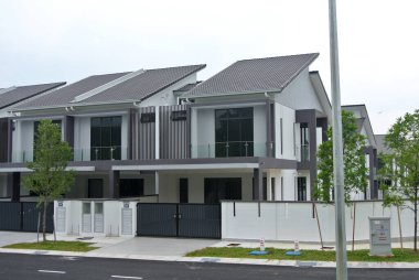 SELANGOR, MALAYSIA - JUNE 18, 2022: New double-story terrace house under construction in Malaysia. This house has a wide front porch and is fenced. Has basic facilities.