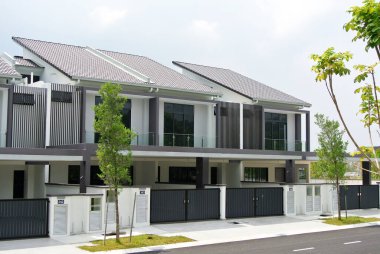 SELANGOR, MALAYSIA - JUNE 18, 2022: New double-story terrace house under construction in Malaysia. This house has a wide front porch and is fenced. Has basic facilities.